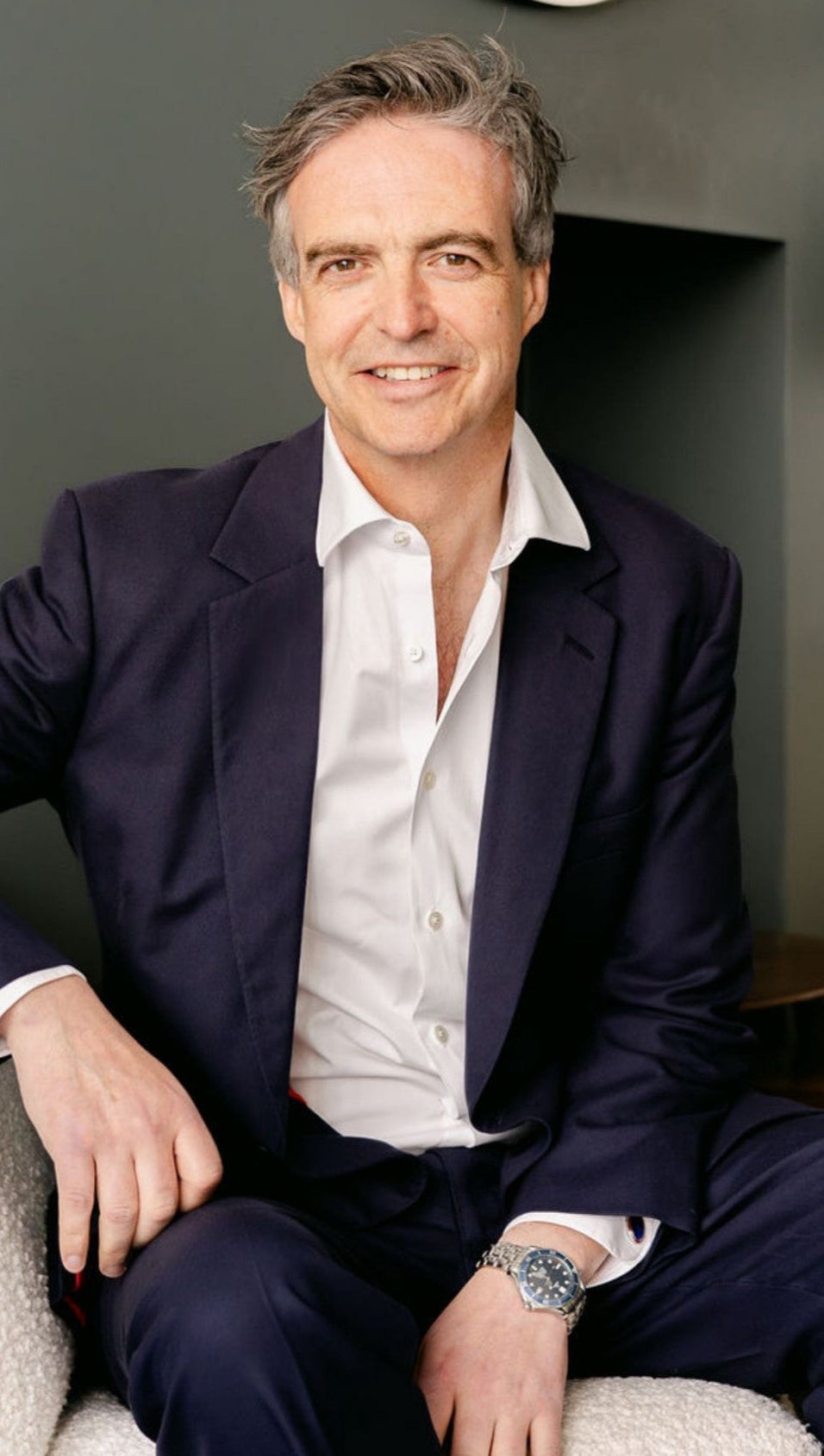 Dr Geoffrey Mullan leading longevity Doctor sitting in a dark blue suit